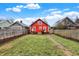 Expansive backyard with a lush green lawn, deck, and classic red house with white trim at 4616 Carrollton Ave, Indianapolis, IN 46205