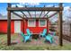 Cozy backyard patio with pergola and fire pit surrounded by four Adirondack chairs at 4616 Carrollton Ave, Indianapolis, IN 46205