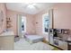 Cozy bedroom with a play kitchen, pink walls, and lots of natural light at 4616 Carrollton Ave, Indianapolis, IN 46205