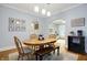 Charming dining room featuring an oval table, hardwood floors, and an arched entry to the living room at 4616 Carrollton Ave, Indianapolis, IN 46205