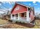 Charming red home with a welcoming front porch and manicured landscaping at 4616 Carrollton Ave, Indianapolis, IN 46205