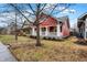 Red two-story home featuring a cozy front porch and well-kept lawn at 4616 Carrollton Ave, Indianapolis, IN 46205