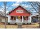 Charming red home with white trim, inviting porch, and well-maintained landscaping at 4616 Carrollton Ave, Indianapolis, IN 46205