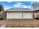 Exterior view of a two-car garage with white doors and a well-maintained driveway at 4616 Carrollton Ave, Indianapolis, IN 46205