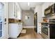 Well-lit kitchen features white cabinetry, granite countertops, stainless steel appliances and hardwood floors at 4616 Carrollton Ave, Indianapolis, IN 46205