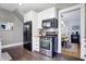 Modern kitchen with stainless steel appliances, white cabinets, hardwood floors, and a view into the dining area at 4616 Carrollton Ave, Indianapolis, IN 46205