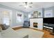 Cozy living room with white brick fireplace, light blue walls and beautiful hardwood floors at 4616 Carrollton Ave, Indianapolis, IN 46205