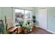 Sunroom with hardwood floors, many houseplants, a large window, and a chair at 4616 Carrollton Ave, Indianapolis, IN 46205