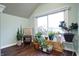 Bright sunroom with hardwood floors and large window with many plants at 4616 Carrollton Ave, Indianapolis, IN 46205