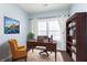 Bright home office with a large wooden desk, ample storage, and a comfortable yellow chair at 5437 Basin Park Dr, Indianapolis, IN 46239