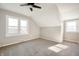 Well-lit bedroom with angled ceilings, carpeted floors, and natural light from two windows at 550 Trowbridge St, Indianapolis, IN 46203