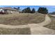 Large, grassy lot with sidewalk access and a partially visible brick building nearby offers excellent development potential at 6094 Horizon Dr, Columbus, IN 47201