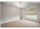 Spacious carpeted room with vaulted ceiling, modern light fixture, and large window with privacy blinds at 8535 Blue Marlin Dr, Indianapolis, IN 46239