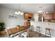 Eat-in kitchen area with stainless appliances, modern light fixtures, raised bar seating, and a modern dining table at 8535 Blue Marlin Dr, Indianapolis, IN 46239