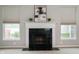 Stylish fireplace with decorative mantel, tile surround, and flanking windows that allow in natural light at 8535 Blue Marlin Dr, Indianapolis, IN 46239
