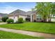 Attractive brick home showcasing a lush green lawn, mature tree, and an American flag in the front yard at 8535 Blue Marlin Dr, Indianapolis, IN 46239