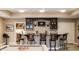 Basement bar area with a stone backsplash, seating, cabinets and a mounted television at 9399 Irishmans Run Ln, Zionsville, IN 46077