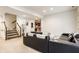 Finished basement with a modern sectional couch, carpeted floors, and staircase leading to the upper level at 9399 Irishmans Run Ln, Zionsville, IN 46077