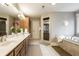 Bright bathroom featuring double vanity, walk-in shower, and a soaking tub at 9399 Irishmans Run Ln, Zionsville, IN 46077