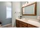 Charming bathroom featuring vanity with marble countertop, framed mirror, and a window at 9399 Irishmans Run Ln, Zionsville, IN 46077