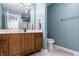 Well-lit bathroom featuring a wooden vanity with sink, toilet and a shower with glass doors at 9399 Irishmans Run Ln, Zionsville, IN 46077