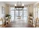 Bright dining room with a large window, hardwood floors, and a modern chandelier at 9399 Irishmans Run Ln, Zionsville, IN 46077