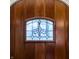Close-up of the custom wooden front door featuring decorative glass detail at 9399 Irishmans Run Ln, Zionsville, IN 46077