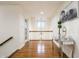 Hallway with wood floors, white railings, chandelier, and a decorative mirror table at 9399 Irishmans Run Ln, Zionsville, IN 46077
