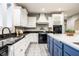 Well-lit kitchen featuring white cabinetry, dark countertops, and a blue kitchen island at 9399 Irishmans Run Ln, Zionsville, IN 46077