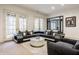 Spacious living room with a modern sectional couch, fireplace, large windows, and neutral color scheme at 9399 Irishmans Run Ln, Zionsville, IN 46077