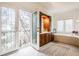 Main bathroom featuring double doors leading to a balcony, vanity, and tub at 9399 Irishmans Run Ln, Zionsville, IN 46077