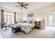 Bright main bedroom with a ceiling fan, sitting area, and double doors at 9399 Irishmans Run Ln, Zionsville, IN 46077