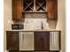 Wet bar with stainless steel appliances, a wine rack, and dark brown cabinetry at 9399 Irishmans Run Ln, Zionsville, IN 46077