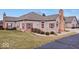 Tan brick ranch home with red shutters, landscaped lawn, and a private fenced backyard at 1088 Laurelwood Ln, Greenwood, IN 46142