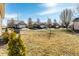 A suburban backyard with a manicured lawn and views of neighboring houses on a street, under a clear blue sky at 10917 Hunter Lake Ln, Indianapolis, IN 46239