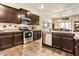 A kitchen island sits in front of stainless steel appliances and dark wood cabinets at 10917 Hunter Lake Ln, Indianapolis, IN 46239
