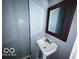 Simple pedestal sink and mirror in updated half-bathroom at 1459 W 33Rd St, Indianapolis, IN 46208
