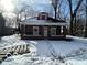 Brick home with front porch, snowy yard, and mature trees at 1459 W 33Rd St, Indianapolis, IN 46208