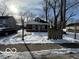 Brick home with front porch, snowy yard, and mature trees at 1459 W 33Rd St, Indianapolis, IN 46208