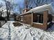 Brick home with side porch and detached garage, snowy yard at 1459 W 33Rd St, Indianapolis, IN 46208