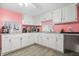 White kitchen cabinets and granite countertops with pink walls at 1743 Sparrow Ave, Indianapolis, IN 46227