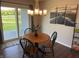 Cozy dining area with stylish chandelier lighting, adjacent to sliding glass doors leading to the outdoor space at 19438 Astoria Ave, Sheridan, IN 46069