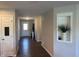 Hallway with dark wood floors leading to a white door, featuring a decorative alcove at 19438 Astoria Ave, Sheridan, IN 46069