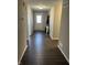 Inviting hallway with dark wood flooring, neutral paint, and a glimpse of the front door at 19438 Astoria Ave, Sheridan, IN 46069