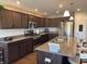 Spacious kitchen featuring dark cabinets, granite countertops, stainless steel appliances, and a convenient island at 19438 Astoria Ave, Sheridan, IN 46069