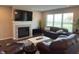 Relaxing living room with a fireplace, large flat-screen TV, comfortable seating, and a view of the well-manicured yard at 19438 Astoria Ave, Sheridan, IN 46069