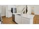 White kitchen with island, stainless steel appliances, and hardwood floors at 19723 Atwater Ave, Sheridan, IN 46069