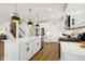 White kitchen with island, stainless steel appliances, hardwood floors at 19723 Atwater Ave, Sheridan, IN 46069