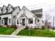 Charming two-story home with white siding, black trim, landscaped yard, and inviting front porch at 2301 Nowland Ave, Indianapolis, IN 46201