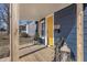 Inviting front porch with yellow door and wooden flooring at 305 Hamilton St, Fortville, IN 46040